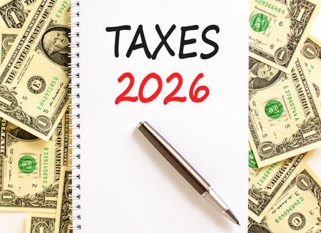 Taxes 2026 new year symbol. Concept words Taxes 2026 on beautiful white note. Beautiful dollar bills...