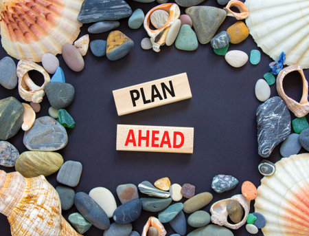 Plan ahead symbol. Concept word Plan ahead on beautiful wooden blocks. Beautiful black paper background. Beautiful sea stones and sea shells. Business plan ahead concept. Copy space.の写真素材