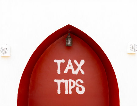 Tax tips symbol. Concept word Tax tips on beautiful white and red wall. Beautiful white and red wall...