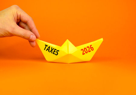 Taxes 2026 new year symbol. Concept words Taxes 2026 on beautiful yellow paper boat. Beautiful...