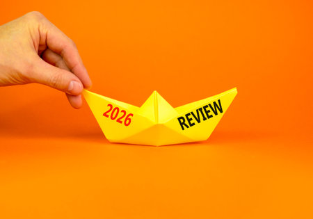 2026 Review symbol. Concept words 2026 Review on beautiful yellow paper boat. Beautiful orange paper...