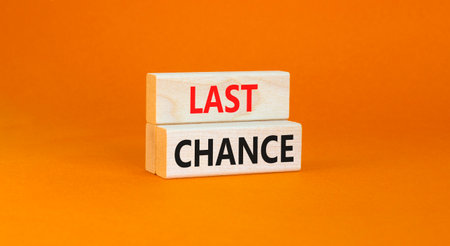 Last chance symbol. Concept word Last chance on beautiful wooden blocks. Beautiful orange paper background. Business last chance concept. Copy space.