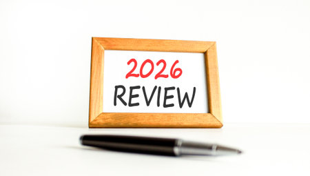 2026 Review symbol. Concept words 2026 Review on beautiful wooden picture frame. Beautiful white paper background. Beautiful black pen. Business and 2026 review concept. Copy space.の写真素材
