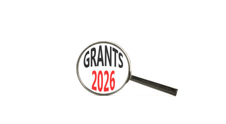Grants 2026 symbol. Concept words Grants 2026 on beautiful white paper. Black magnifying glass. Beautiful white paper background. Business and grants 2026 concept. Copy space.の写真素材