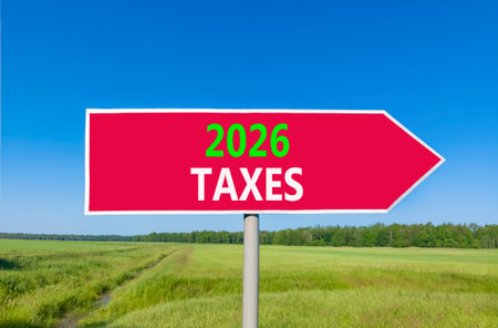 2026 taxes new year symbol. Concept words 2026 taxes on beautiful red road sign. Beautiful green grass field forest and blue sky background. Business and 2026 taxes new year concept. Copy space.の写真素材