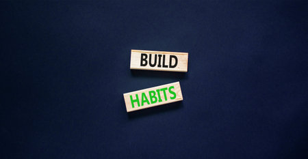 Build habits symbol. Concept word Build habits on beautiful wooden blocks. Beautiful black paper background. Business build habits concept. Copy space.の写真素材