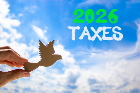 2026 taxes new year symbol. Concept words 2026 taxes on beautiful blue sky. Beautiful blue sky background. Businessman's hand holds wooden bird. Business and 2026 taxes new year concept. Copy space.の写真素材