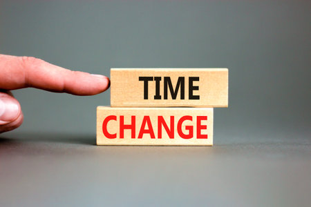 Time change symbol. Concept word Time change on beautiful wooden blocks. Beautiful gray paper...