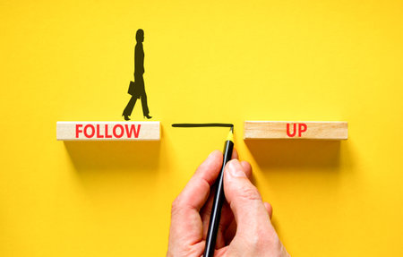 Follow up symbol. Concept word Follow up on beautiful wooden blocks. Beautiful yellow paper background. Businesswoman icon. Business follow up concept. Copy space.の写真素材