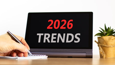 2026 Trends new year symbol. Concept words 2026 Trends on beautiful black tablet screen. Beautiful white background. Businessman's hand. Business and 2026 Trends new year concept. Copy space.の写真素材