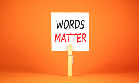 Words matter symbol. Concept word Words matter on beautiful white paper. Beautiful wooden clothespin. Beautiful orange background. Business words matter concept. Copy space.の写真素材