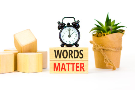 Words matter symbol. Concept word Words matter on beautiful wooden blocks. Beautiful white paper background. Beautiful black alarm clock. Business words matter concept. Copy space.の写真素材