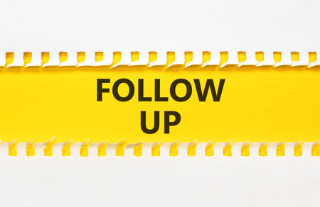 Follow up symbol. Concept word Follow up on beautiful white paper. Beautiful yellow paper background. Business follow up concept. Copy space.の写真素材