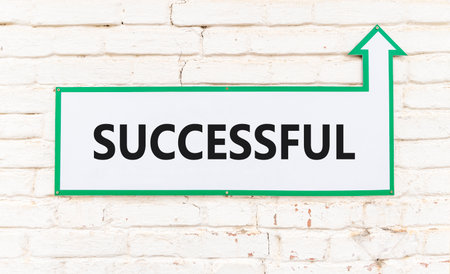 Successful symbol. Concept word Successful on beautiful white sign on old white brick wall. Beautiful brick old white wall background. Business successful concept. Copy space.の写真素材