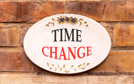 Time change symbol. Concept word Time change on beautiful white sign on brown old brick wall. Beautiful brown old brick wall background. Business time change concept. Copy space.の写真素材