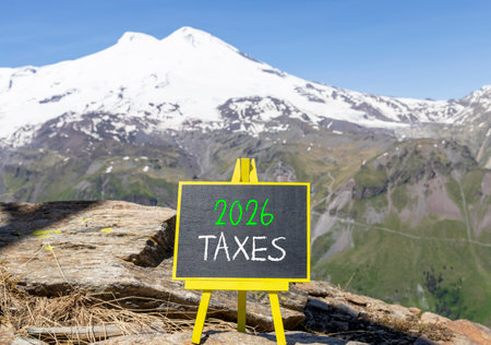 2026 taxes new year symbol. Concept words 2026 taxes on beautiful black blackboard. Beautiful mountain Elbrus and blue sky background. Business and 2026 taxes new year concept. Copy space.の写真素材