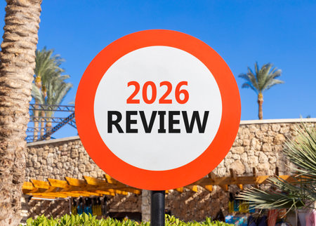 2026 Review symbol. Concept words 2026 Review on beautiful white and red road sign. Beautiful palm trees palm-trees and blue sky background. Business and 2026 review concept. Copy space.の写真素材