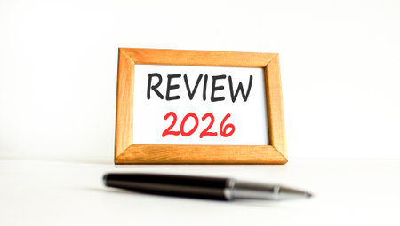 Review 2026 symbol. Concept words Review 2026 on beautiful wooden picture frame. Beautiful white paper background. Beautiful black pen. Business and review 2026 concept. Copy space.の写真素材