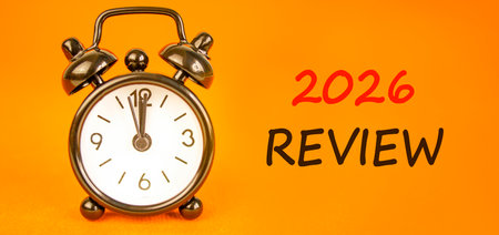 2026 Review symbol. Concept words 2026 Review on beautiful orange paper. Beautiful orange paper background. Beautiful black alarm clock. Business and 2026 review concept. Copy space.の写真素材