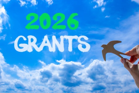 2026 Grants symbol. Concept words 2026 Grants on beautiful blue sky. Beautiful blue sky background. Businessman's hand holds wooden bird. Business and 2026 grants concept. Copy space.の写真素材