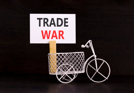 Trade war symbol. Concept word Trade war on beautiful white paper. Beautiful wooden clothespin. Miniature white bicycle. Beautiful black background. Business trade war concept. Copy space.の写真素材