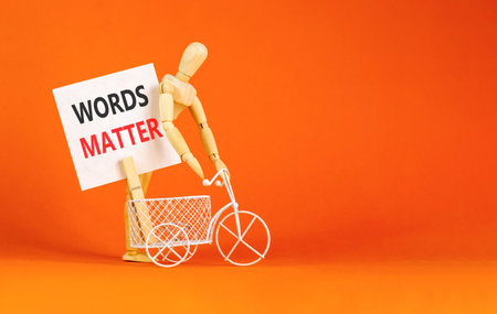 Words matter symbol. Concept word Words matter on beautiful white paper. Beautiful wooden clothespin. Businessman's model. Beautiful orange background. Business words matter concept. Copy space.の写真素材