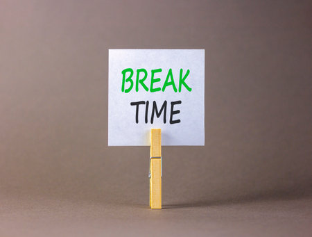 Break time symbol. Concept Break word time on beautiful white paper. Beautiful wooden clothespin. Beautiful gray background. Business break time concept. Copy space.の写真素材