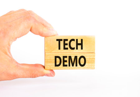 Tech demo symbol. Concept word Tech demo on beautiful wooden blocks. Beautiful white paper background. Businessman's hand. Business tech demo concept. Copy space.の写真素材