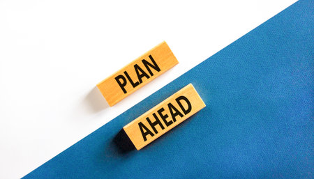 Plan ahead symbol. Concept word Plan ahead on beautiful wooden blocks. Beautiful white and blue paper background. Business plan ahead concept. Copy space.の写真素材