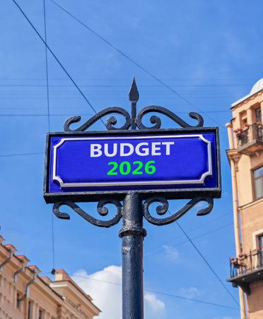 Budget 2026 symbol. Concept words Budget 2026 on beautiful blue road sign. Beautiful blue sky and buildings background. Business and budget 2026 concept. Copy space.の写真素材