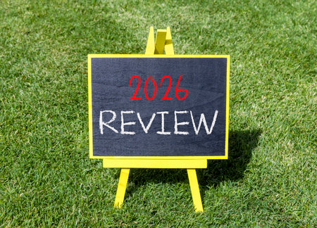 2026 Review symbol. Concept words 2026 Review on beautiful black blackboard. Beautiful green grass background. Business and 2026 review concept. Copy space.の写真素材