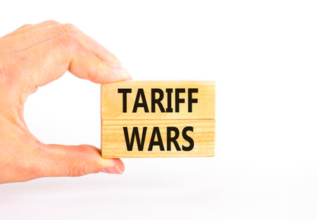 Trade tariff wars symbol. Concept word Tariff wars on beautiful wooden blocks. Beautiful white paper background. Businessman's hand. Business trade tariff wars concept. Copy space.の写真素材