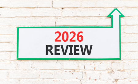 2026 Review symbol. Concept words 2026 Review on beautiful white sign with arrow. Beautiful old white brick wall background. Business and 2026 review concept. Copy space.の写真素材