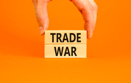 Trade war symbol. Concept word Trade war on beautiful wooden blocks. Beautiful orange paper background. Businessman's hand. Business trade war concept. Copy space.の写真素材
