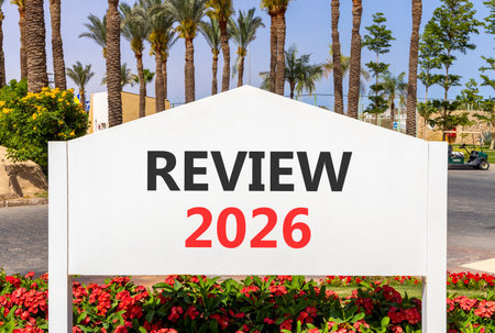 Review 2026 symbol. Concept words Review 2026 on beautiful white road sign. Beautiful palm trees...
