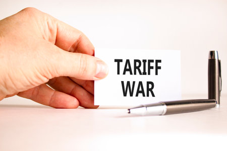 Trade tariff war symbol. Concept word Tariff war on beautiful white card. Beautiful black pen. Beautiful white paper background. Businessman's hand. Business trade tariff wars concept. Copy space.の写真素材