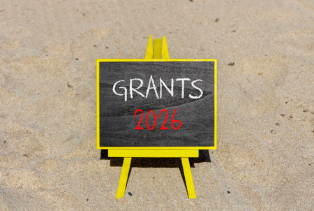 Grants 2026 symbol. Concept words Grants 2026 on beautiful black blackboard. Beautiful sand beach...