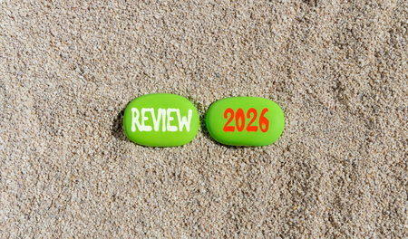 Review 2026 symbol. Concept words Review 2026 on beautiful green stones on sand beach. Beautiful...