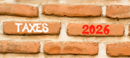 Taxes 2026 new year symbol. Concept words Taxes 2026 on beautiful brown brick wall. Beautiful brown brick wall background. Business and taxes 2026 new year concept. Copy space.の写真素材