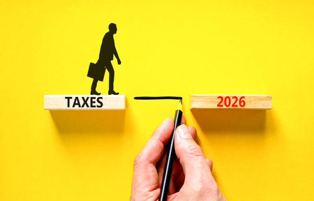 Taxes 2026 symbol. Concept words Taxes 2026 on beautiful wooden blocks. Beautiful yellow background....