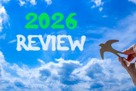 2026 Review symbol. Concept words 2026 Review on beautiful blue sky. Beautiful blue sky background. Businessman's hand holds wooden bird. Business and 2026 review concept. Copy space.の写真素材