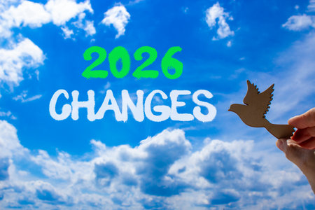 2026 Changes symbol. Concept words 2026 Changes on beautiful blue sky. Beautiful blue sky background. Businessman's hand holds wooden bird. Business and 2026 changes concept. Copy space.の写真素材