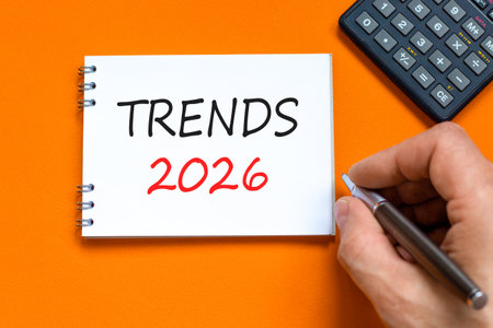 Trends 2026 new year symbol. Concept words Trends 2026 on beautiful white note. Black calculator. Beautiful orange background. Businessman's hand. Business and Trends 2026 new year concept. Copy spaceの写真素材