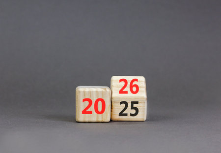 Business concept of 2026 new year symbol. Beautiful turned wooden cube and changed number 2025 to 2026. Beautiful gray table gray background, copy space. Business 2026 happy new year concept.の写真素材