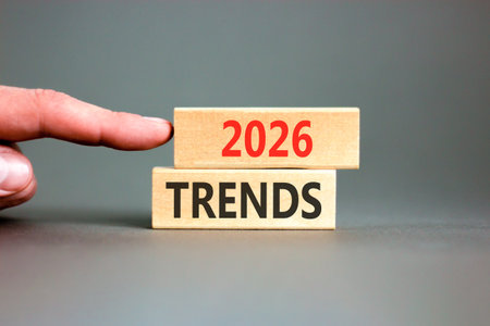 2026 Trends new year symbol. Concept words 2026 Trends on beautiful wooden blocks. Beautiful gray paper background. Businessman's hand. Business and 2026 Trends new year concept. Copy space.の写真素材
