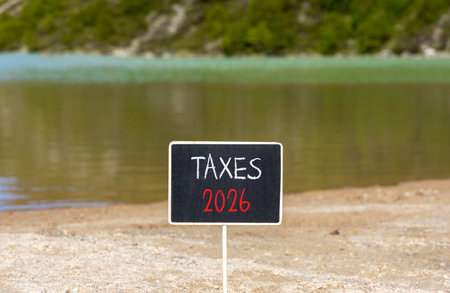 Taxes 2026 new year symbol. Concept words Taxes 2026 on beautiful black blackboard. Beautiful mountain lake sand beach background. Business and taxes 2026 new year concept. Copy space.の写真素材