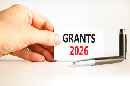Grants 2026 symbol. Concept words Grants 2026 on beautiful white card. Beautiful white paper background. Businessman's hand. Business and grants 2026 concept. Copy space.の写真素材