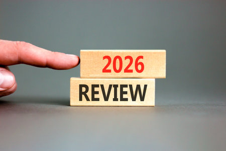 2026 Review symbol. Concept words 2026 Review on beautiful wooden blocks. Beautiful gray paper background. Businessman's hand. Business and 2026 review concept. Copy space.の写真素材