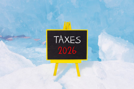 Taxes 2026 new year symbol. Concept words Taxes 2026 on beautiful black blackboard. Beautiful blue...
