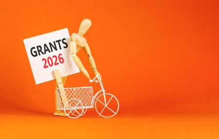 Grants 2026 symbol. Concept words Grants 2026 on beautiful white card. Beautiful orange paper background. Businessman's model. Business and grants 2026 concept. Copy space.の写真素材